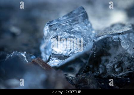 Ein Eisbrocken liegt auf dem Boden in der Nähe eines kleinen Haufens Stockfoto