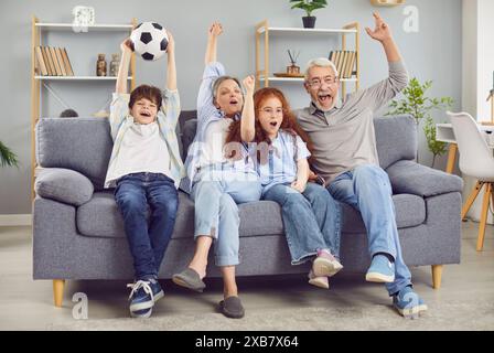 Begeisterte Familien-Großeltern und Kinder-Fans, die Sportfußballspiele im fernsehen ansehen. Stockfoto