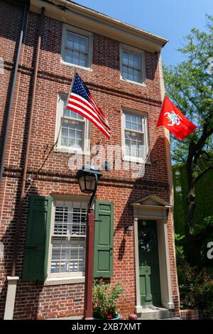 Haus mit amerikanischer und litauischer Flagge auf der Elfreth's Alley in der Altstadt von Philadelpia. Pennsylvania, USA. Stockfoto