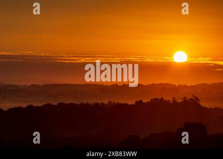 Ein Sonnenaufgang über Hügeln und Bäumen, perfekte Zeit für die Aussicht Stockfoto