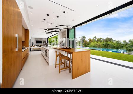 Geräumige Küche und Wohnzimmer mit Blick auf den Pool Stockfoto