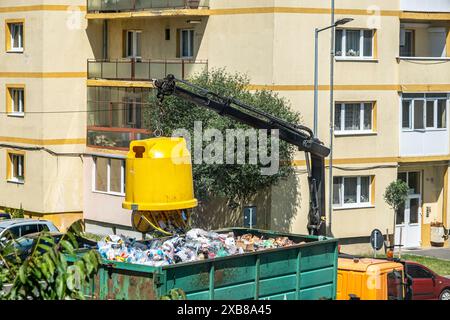 Sibiu City, Rumänien - 27. Mai 2024. Arbeiter keimen Container mit selektivem Müll in den Anhänger, Straßenreinigung, Männer laden Abfall aus Mülltonnen Stockfoto