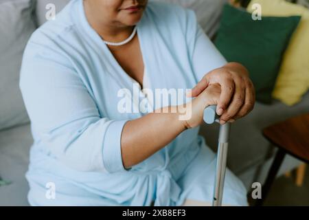 Ältere afroamerikanische Frau erwartet, dass ein Arzt einen Stock in der Hand hält, während er auf dem Bus sitzt Stockfoto