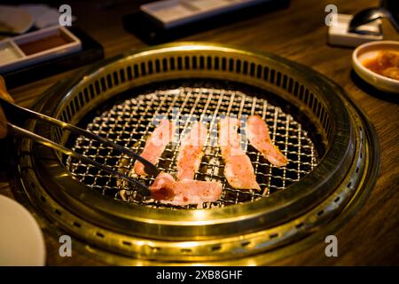 Eine Person, die mit Zuschauern Speck grillt Stockfoto