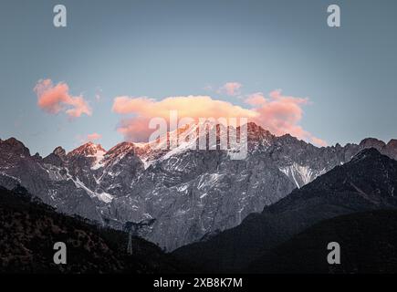 Die Sonne untergeht hinter dem schneebedeckten Berg Stockfoto
