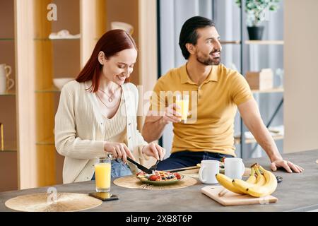 Eine rothaarige Frau und ein bärtiger Mann genießen ein gemütliches Frühstück in ihrer modernen Küche. Stockfoto