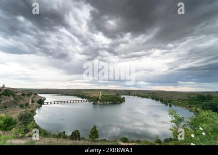 Toller Panoramablick auf das malerische Dorf Maderuelo und den Linares Stausee in der Provinz Segovia an einem Tag mit stürmischem Himmel. Stockfoto