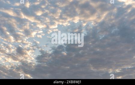 Stratiforme Wolken in der Abenddämmerung werden durch Sonnenlicht beleuchtet. Stockfoto