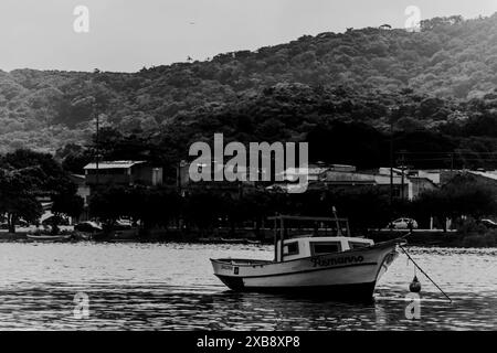 Boot in der Nähe des Berges mit Häusern auf dem Wasser Stockfoto