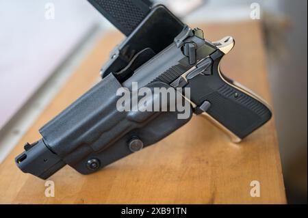 Detail der 9-mm-Pistole, die im Polizeiholster am IPSC-Gürtel eingehängt ist Stockfoto