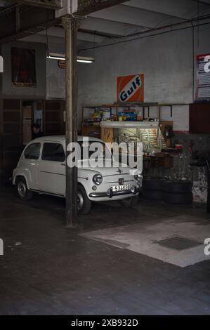 Eine vertikale Aufnahme einer alten Automechanikerwerkstatt mit einem weißen Sitz 600 innen Stockfoto