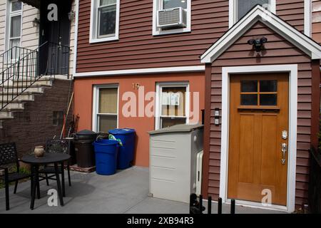 Ein rotes Haus mit zwei weißen Fenstern und einer Eingangstür draußen Stockfoto