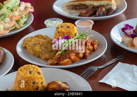 Verschiedene Gruppen, die eine Mahlzeit mit Tellern mit Essen auf einem Tisch genießen Stockfoto