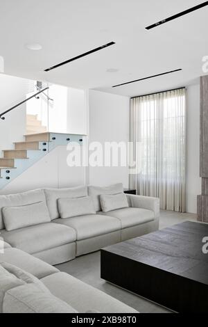 Ein geräumiges Sofa mit einer Treppe im Hintergrund Stockfoto