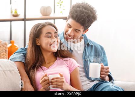Niedliches Teenager-Paar, Das Sich Auf Der Couch Mit Kaffee Zu Hause Entspannt Stockfoto