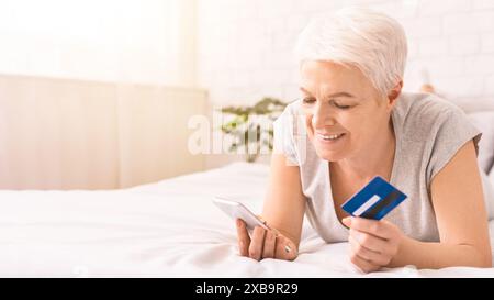 Seniorin Mit Kreditkarte Online Mit Smartphone Einkaufen Stockfoto