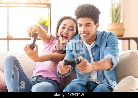 Teenager-Paar, das Videospiele auf der Couch zu Hause spielt Stockfoto