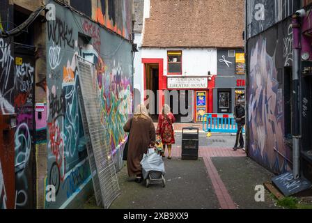 Die Leute spazieren durch die mit Graffiti übersäte Gasse King Place an der Bond St und gegenüber der Theatre Royal Stage Door in Bond St, Brighton, East Sussex, Großbritannien. Stockfoto