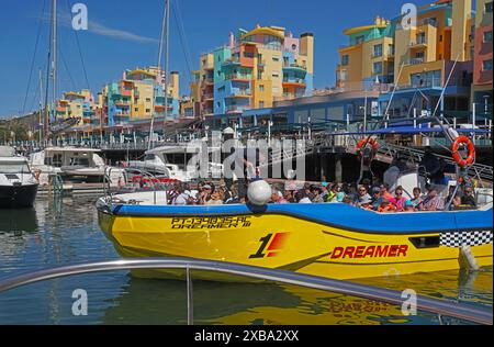 Touristenboot, das von der farbenfrohen Albufeira Marina für eine Küstenrundfahrt an der Algarve zur Benagil Cave und zurück fährt. Stockfoto