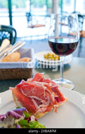 Spanische Tapa: iberischer Schinken mit einem Glas Rotwein. Spanien. Stockfoto