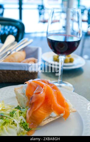 Spanische Tapa: geräucherter Lachs mit einem Glas Rotwein. Spanien. Stockfoto