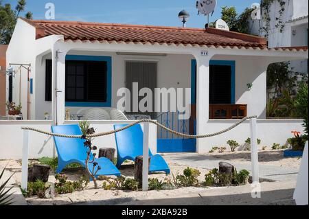 Portugal, Olhao, Algarve Mai 2024. Ilha da Armona. Zwei blaue Sonnenliegen vor einem kleinen Haus Stockfoto