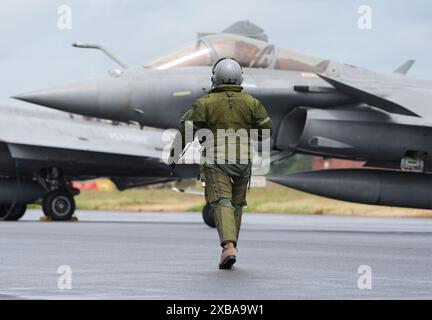 11. Juni 2024, Schleswig-Holstein, Jagel: Ein Pilot der französischen Luftwaffe geht während des NATO-Luftwaffenmanövers „Tiger Meet“ auf dem Gelände des Tactical Air Force Wing 51 „Immelmann“ über den Flugplatz zu seinem Kampfjet Dassault Rafale. Elf NATO-Staaten sowie die Schweiz und Österreich nehmen an der NATO-Übung "Tiger Meet" Teil. Im Juni werden voraussichtlich rund 60 Jets und Hubschrauber teilnehmen. Rund 1100 weitere Soldaten werden vor Ort sein. Der taktische Luftwaffenflügel 51 „Immelmann“ feiert im Rahmen dieser großen Übung sein 30-jähriges Bestehen. Foto: Marcus Brandt/dpa Stockfoto