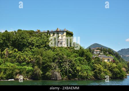 Ein heruntergekommenes Gebäude in der Nähe von Pallanza, von einer Fähre auf dem Lago Maggiore aus gesehen. Stockfoto