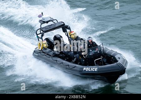 Eine britische POLIZEIRIPPE oder ein starres aufblasbares Boot, das mit Geschwindigkeit in der Solent vor der Küste von Hampshire fährt. Das Boot hat eine Besatzung von zwei Polizisten Stockfoto