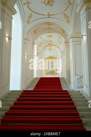 Bratislava, Slowakei, 23-05-24. Das Innere der Burg Bratislava, mit steiler Treppe mit rotem Teppich und einem goldvergoldeten Spiegel an der Spitze des Stockwerks Stockfoto