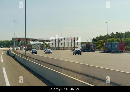 Salles-d'Aude, Frankreich - 16. Mai 2023: Pkw und Lkw fahren an einem sonnigen Tag durch eine Mautstelle. Stockfoto