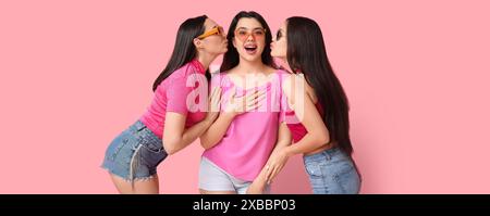 Emotionale junge Frauen in Sonnenbrille auf rosa Hintergrund Stockfoto