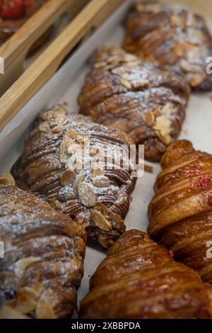 Nahaufnahme frischer französischer Croissants mit Mandeln und Zuckerpulver in der Bäckerei Stockfoto