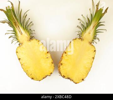 Ananas in zwei Hälften geschnitten. Zwei Hälften einer Ananas auf weißem Hintergrund, Draufsicht. Stockfoto