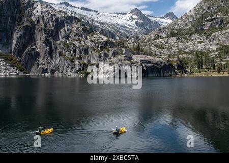 Die wunderschöne Berglandschaft und der hochgelegene See in der Wildnis der Shasta Trinity Alps. Ein Paar entfernte Kajakfahrer paddeln über den See. Stockfoto