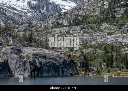 Die wunderschöne Berglandschaft und der hochgelegene See in der Wildnis der Shasta Trinity Alps. Ein Paar entfernte Kajakfahrer paddeln über den See. Stockfoto