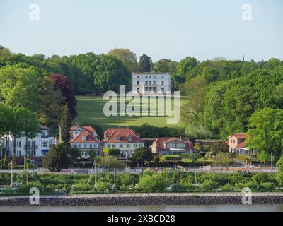 Grüner Park mit einem großen Herrenhaus im Hintergrund und Villen am Ufer, Elbe, Hamburg, Norddeutschland, Deutschland Stockfoto