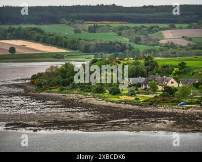 Häuser an der Küste mit grünen Feldern und bewaldeten Hügeln im Hintergrund, inverness, schottland, Großbritannien Stockfoto