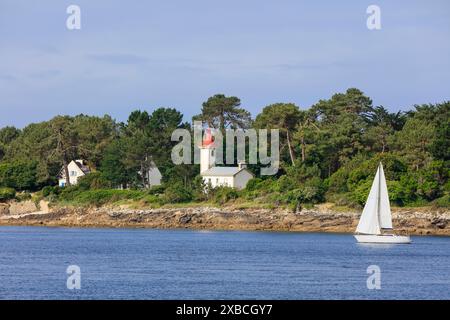 Küste von Combrit, Bezirk Le Moguer mit Leuchtturm Phare de Sainte Marine und Segelboot, von Benodet aus gesehen, Departement Finistere Penn AR Bed Stockfoto