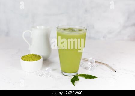 Japanischer Eismatcha Latte, grüner Tee mit Milch, Sojamilch mit Strohhalm im Glas vor hellem Hintergrund. Grüner Tee. Stockfoto
