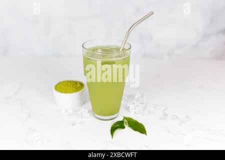 Japanischer Eismatcha Latte, grüner Tee mit Milch, Sojamilch mit Strohhalm im Glas vor hellem Hintergrund. Grüner Tee. Stockfoto