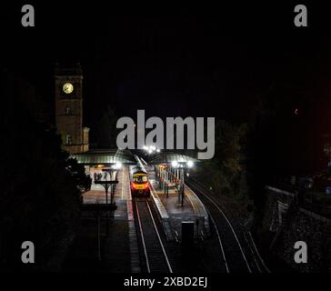 Erster TransPennine Express Siemens-Zug der Baureihe 185 185124 am Bahnhof Ulverston mit dem Uhrenturm in der Nacht Stockfoto