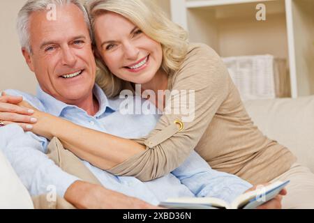 Attraktive gesunde ältere Mann Frau Paar zu Hause lächelnd ein Buch lesen Stockfoto