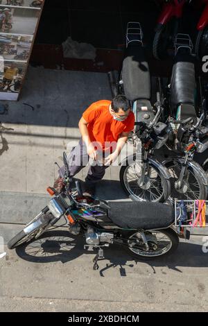 SAIGON, VIETNAM, 13. Dezember 2017, Ein Mann steht in einem Motorradverleih in Saigon Stockfoto