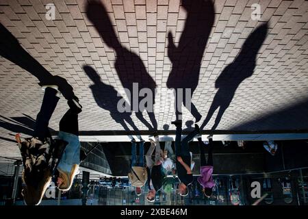 St. Petersburg, Russland. Juni 2024. Silhouetten auf Straßenfliesen in Form kontrastierender Schatten, die an einem Sommertag an der Straße vorbeiziehen. Quelle: SOPA Images Limited/Alamy Live News Stockfoto