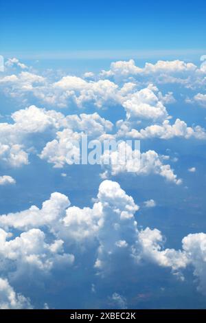 Flauschige Wolken, die im Himmel schweben, Blick aus dem Flugzeug, während sie über das Wolkenmeer fliegen Stockfoto