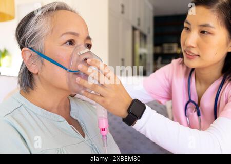 Asiatische Krankenschwester Gesundheitspersonal hilft ältere asiatische Frau mit Sauerstoffmaske. Gesundheitswesen, Seniorenleben, Ruhestand, Hilfe zu Hause, Besuch, unverändert Stockfoto