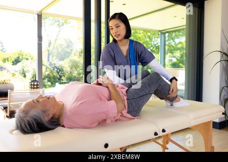 Physiotherapeutin hilft älteren asiatischen Frauen bei physikalischen Therapieübungen. Gesundheitshilfe, Heim- und Physiotherapie, Ruhestand unverändert Stockfoto