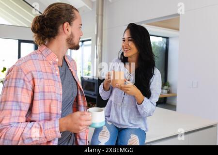 Junges vielseitiges Paar, das Kaffee zusammen genießt Stockfoto