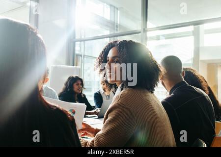 Geschäftsfrau, die mit verschiedenen Kollegen zusammenarbeitet und an einem produktiven Geschäftstreffen in einem modernen Büro teilnimmt. Stockfoto